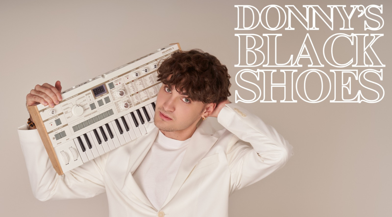 JOVEN VESTIDO DE BLANCO CON TECLADO AL HOMBRO