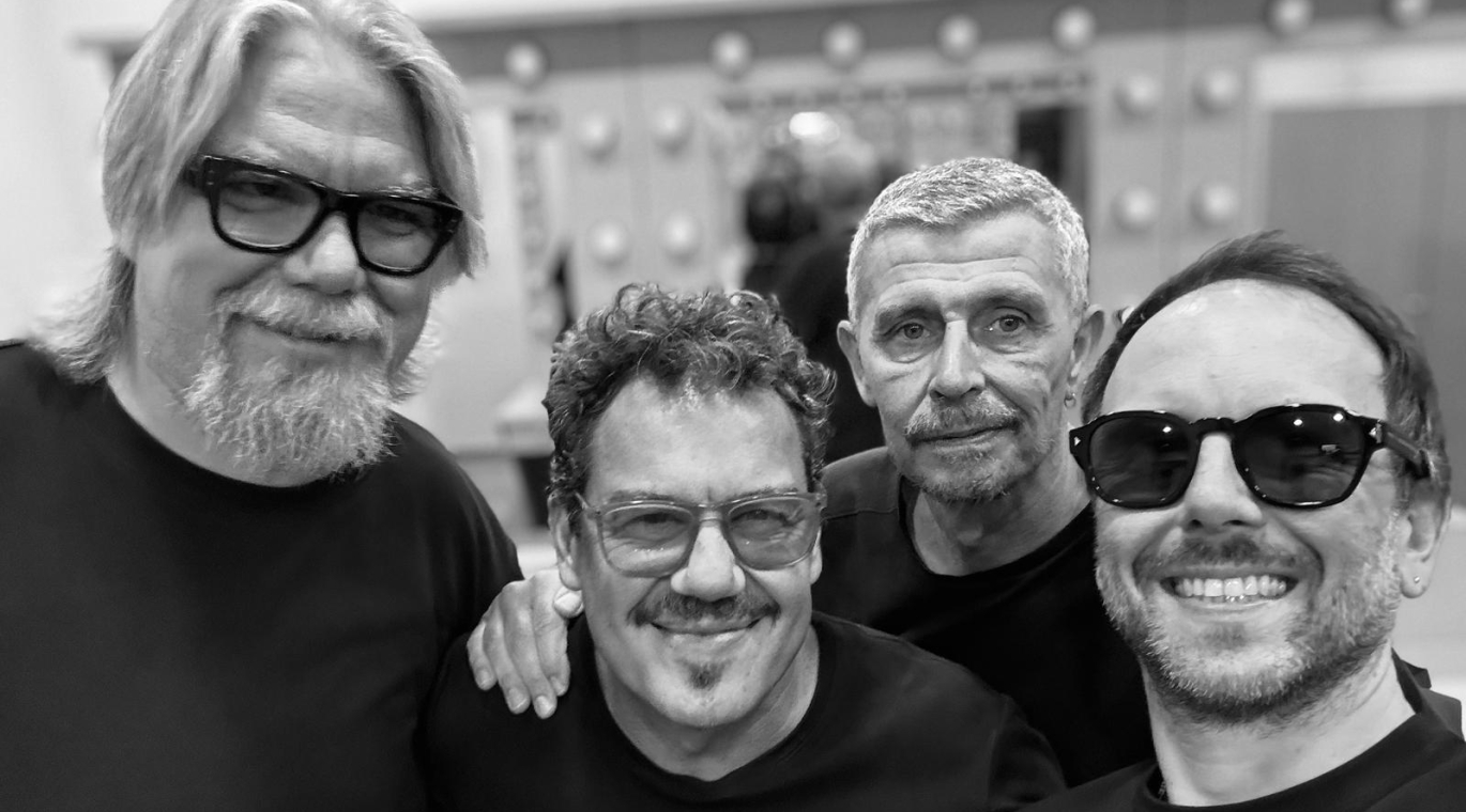 FOTO EN BLANCO Y NEGRO DE CUATRO HOMBRES DE FRENTE